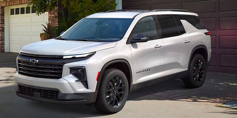 White 2025 Chevrolet Traverse parked in front of a house