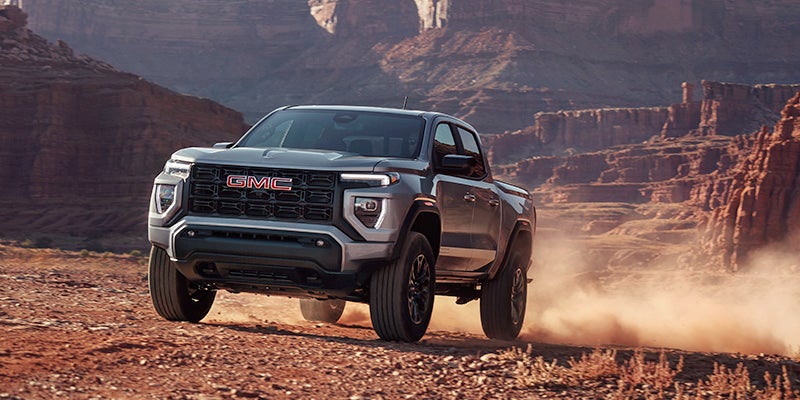 Silver 2024 GMC Canyon driving through the desert