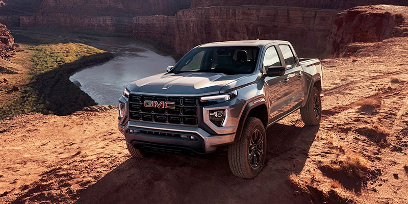 Silver 2024 GMC Canyon driving through the desert