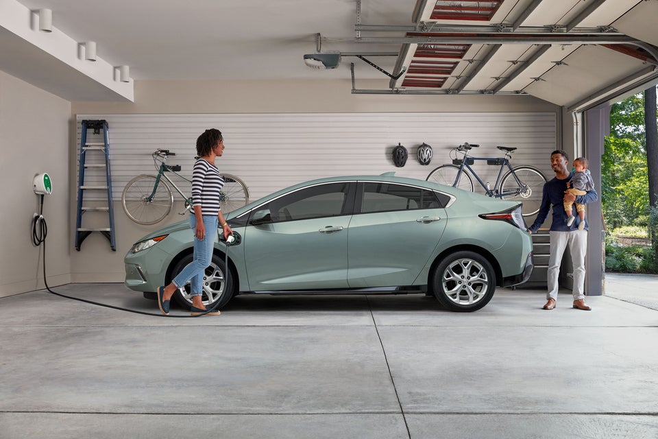 a woman charging her EV in her garage